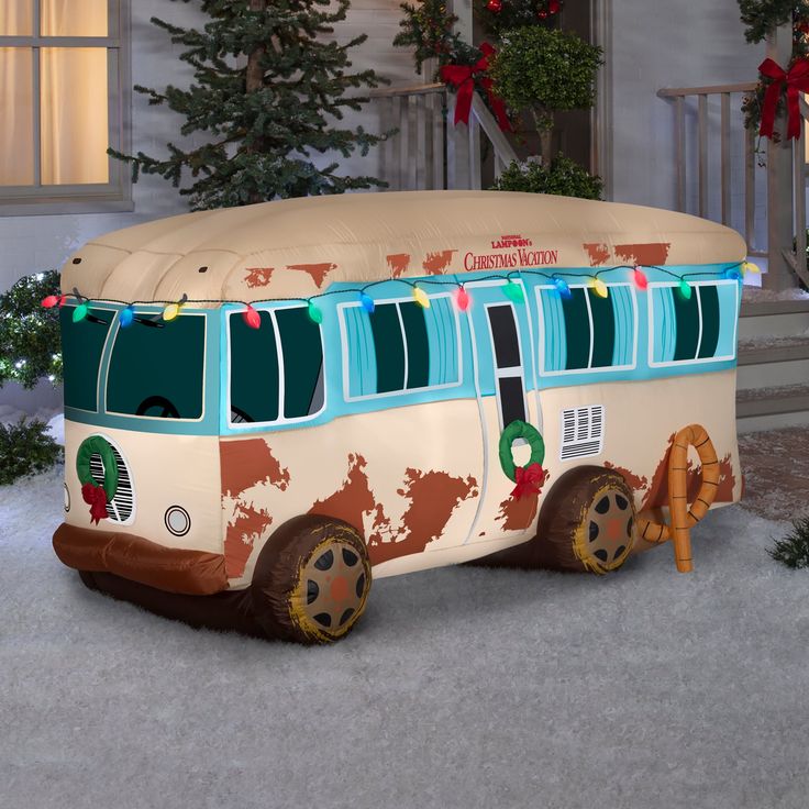 an inflatable bus decorated with christmas lights and garlands sits on the snow