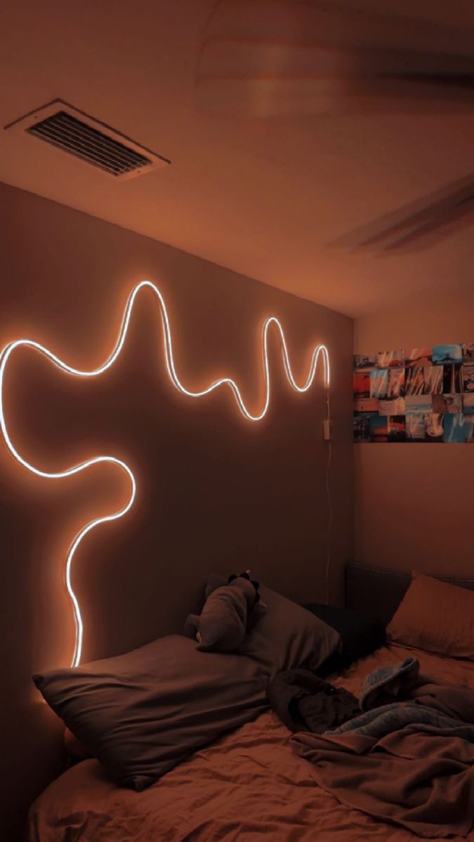 a room with a bed and neon lights on the wall