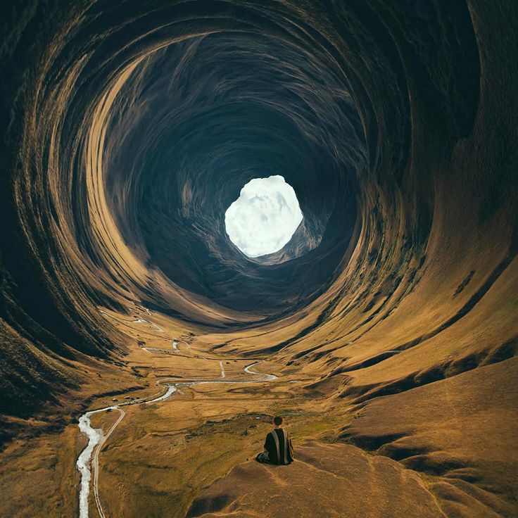 a man is sitting in the middle of a large tunnel with water running through it