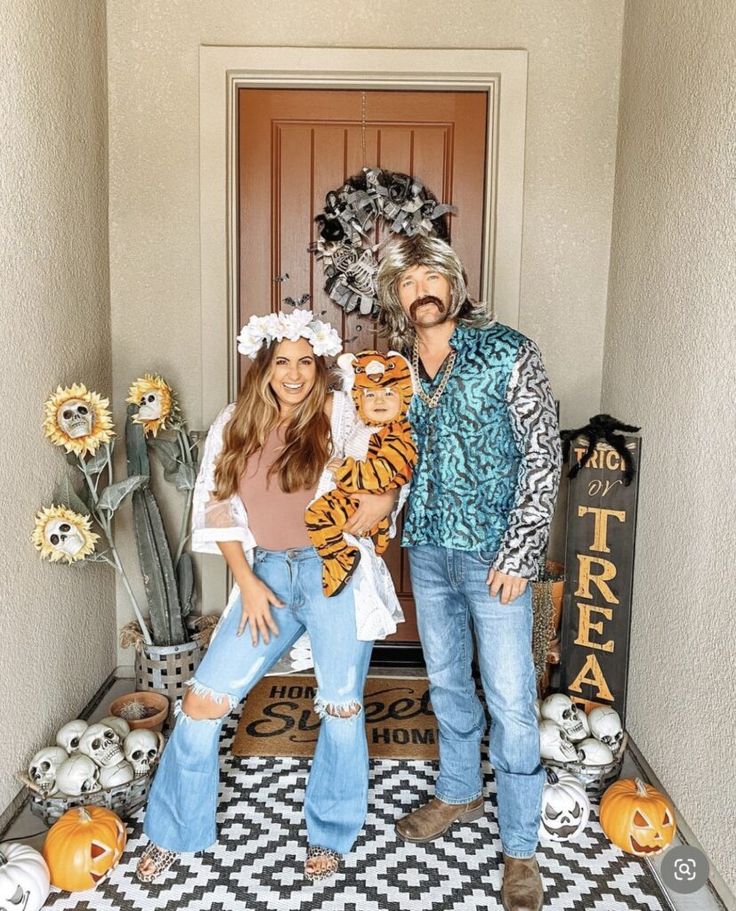 a man and woman standing in front of a door with halloween decorations on the floor