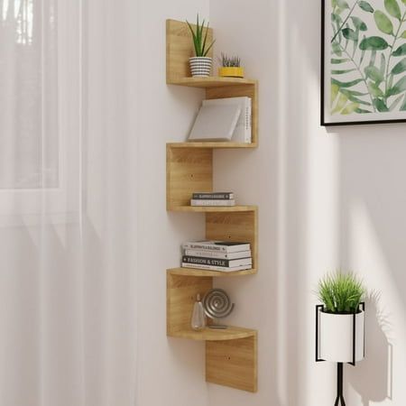 three wooden shelves with plants and books on them in the corner of a living room