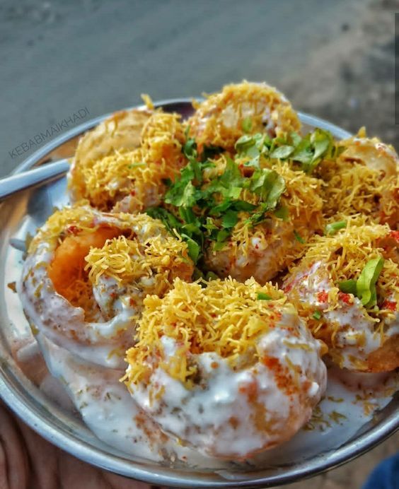 a person holding a silver plate with food on it