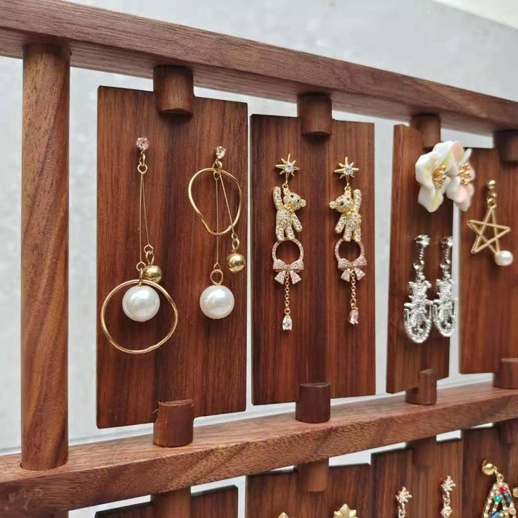 a wooden shelf with earrings on it