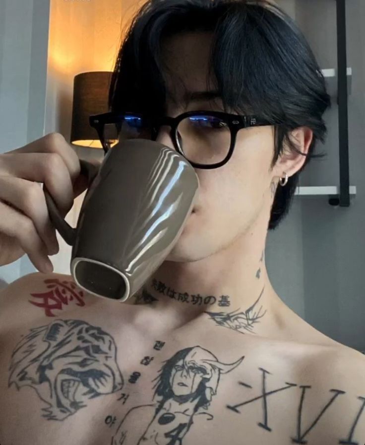 a shirtless man with glasses holding a coffee mug