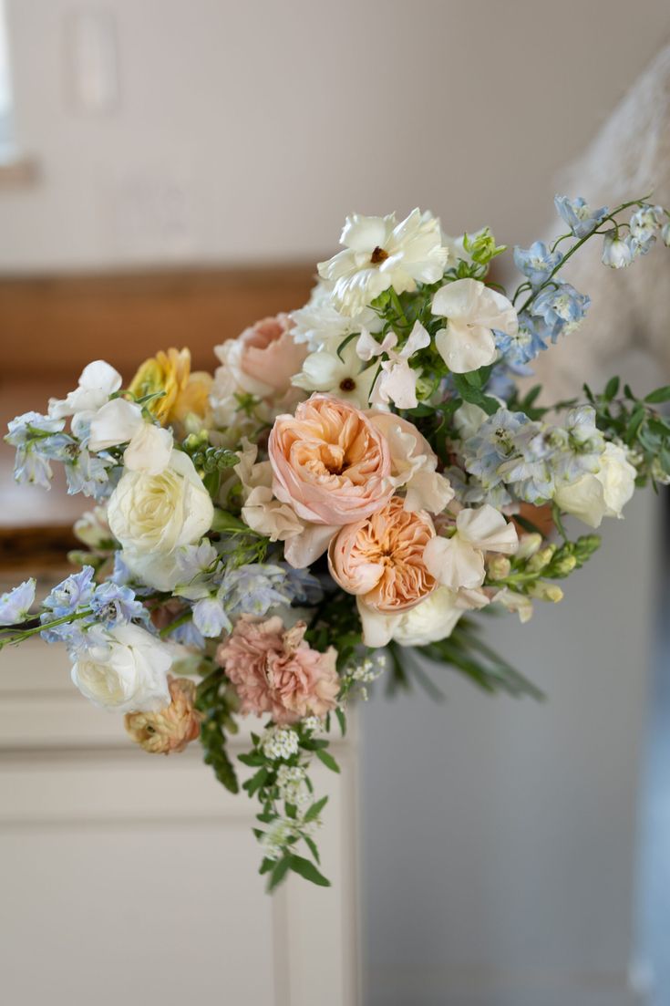 a bouquet of flowers sitting on top of a white countertop next to a window