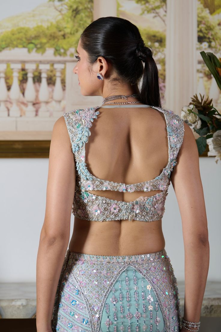 An aquatic vision immersed in the sparkling allure of sequins, crystals, cut dana, and bead detailing. This pastel blue hue makes a perfect ensemble for your summer celebrations. Daria lehenga includes a designer blouse with a sweetheart neckline and a structured mermaid lehenga skirt heavily adorned with floral and geometrical motifs hand-embroidered. A serene net dupatta complements the whole outfit. Style this fairytale mermaid lehenga for this summer wedding with your best statement jewelry and dazzle up the soiree. Sleeveless blouse with a sweetheart neckline adorned with cut-out work and highlighted with sparkling crystals and beads. Flowy translucent butterfly net dupatta. Lehenga skirt adorned with zardozi and zari handwork crafting the flower and geometrical motifs. Metal hook at Sleeveless Crop Top Lehenga, Net Lehenga Blouse Designs, Unique Blouse Designs For Lehenga, Mermaid Lehenga, Translucent Butterfly, Lehenga Ideas, Geometrical Motifs, After Wedding Dress, Neck Lines