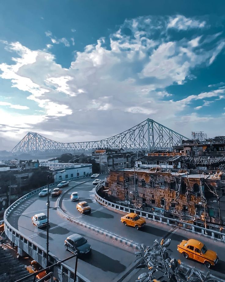 cars are driving on the road in front of a bridge