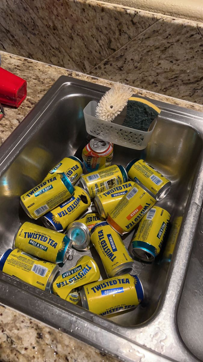 a kitchen sink filled with cans of beer