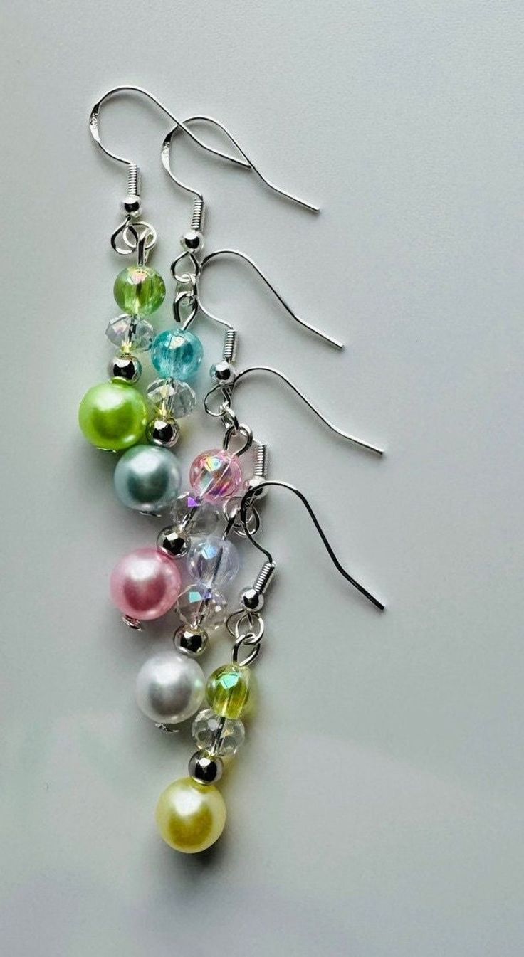 three pairs of dangling earrings with multicolored pearls and swarong crystal beads