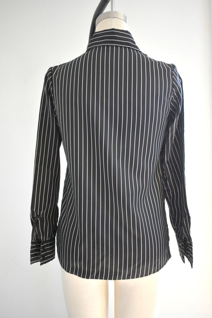 "Description: 1970s black and white striped silky polyester blouse. Long sleeves with pleated shoulders. Button front. Condition: In great condition, with no holes or stains. Designer: It's Gailord Stated Size: 10 Measurements: Armpit to armpit: 18\" Shoulder to shoulder: 14.5\" Sleeve length: 23\" Overall length: 23\" Waist: up to 35\" ---> If you need an order shipped by a particular date or shipped via a quicker method, please ask PRIOR to purchase to see if we can accommodate that request Elegant Pinstripe Button-up Blouse, Elegant Pinstripe Blouse For Formal Occasions, Elegant Formal Pinstripe Blouse, Elegant Pinstripe Tops With Button Closure, Elegant Vertical Striped Workwear Blouse, Elegant Office Tops With Vertical Stripes, Elegant Workwear Blouse With Vertical Stripes, Elegant Vertical Stripes Blouse For Work, Elegant Vertical Stripe Office Tops