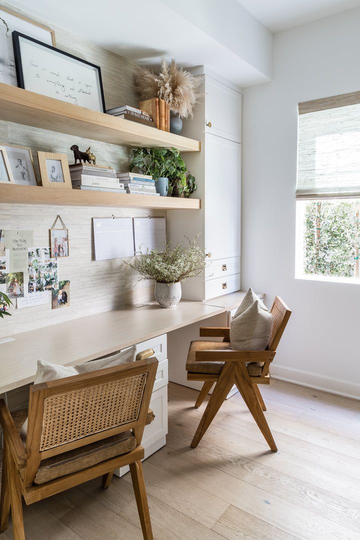 an instagram photo of a home office with white walls and wood furniture, along with pictures on the wall