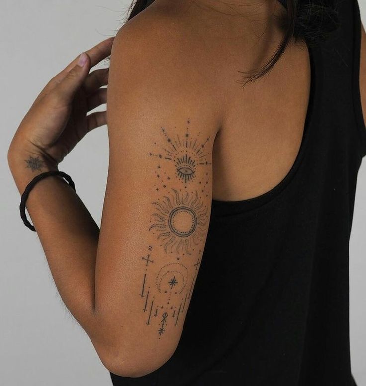 a woman with a sun and stars tattoo on her arm