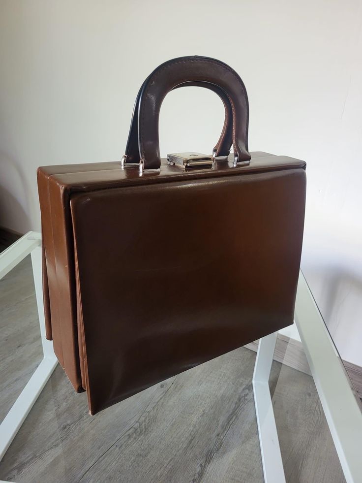 Vintage leather briefcase, beautiful chocolate brown leather satchel, small hand luggage with carrying handle, fabric interior with a closing pocket, a small mirror, lock with key, vintage briefcase from the 60s, ideal for decoration, some traces of wear on the leather and faded interior fabric and some stains (see photos for more details). Dimensions: Width 32 cm Depth 13 cm Height 24 cm Weight: 1,320 kg Vintage Rectangular Briefcase For Business, Vintage Business Briefcase Rectangular Case, Vintage Rectangular Business Briefcase, Vintage Business Cases With Leather Lining, Brown Rectangular Box Bag With Carry Handle, Vintage Rectangular Business Case, Classic Brown Box Bag With Top Handle, Classic Brown Box Bag With Top Carry Handle, Vintage Rectangular Briefcase For Business Trips