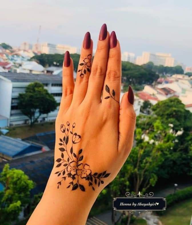 a woman's hand with two tattoos on it