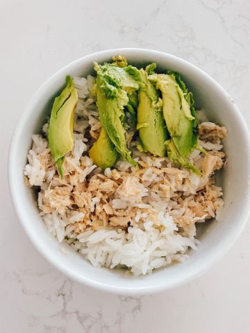 a white bowl filled with rice and avocado