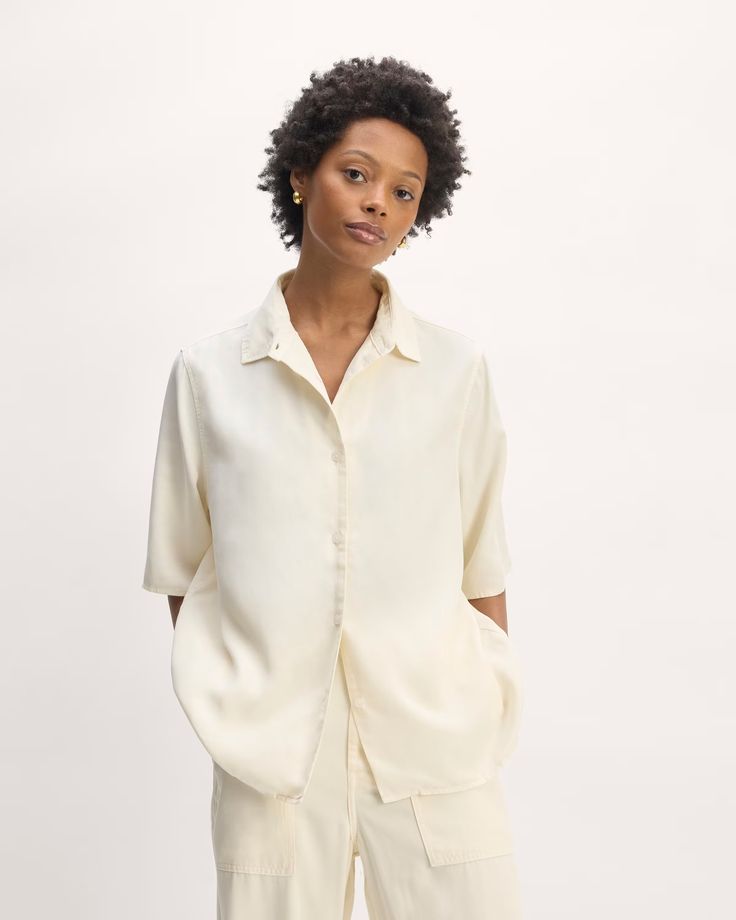 About This Style.  This piece features an oversized fit, shirt collar, front button closure and cuffs, short sleeves, and straight hem. Relaxed Button-up Shirt With Rolled Sleeves, Classic Shirt With Roll-up Sleeves For Day Out, Daywear Shirt With Lapel Collar And Button Closure, Daywear Shirt With Lapel Collar And Placket, Shirt With Placket And Lapel Collar For Daywear, Relaxed Fit Shirt With Roll-up Sleeves For Daywear, Summer Shirt With Lapel Collar And Button Closure, Spring Relaxed Fit Camp Shirt For Daywear, Chic Shirt With Lapel Collar And Relaxed Fit