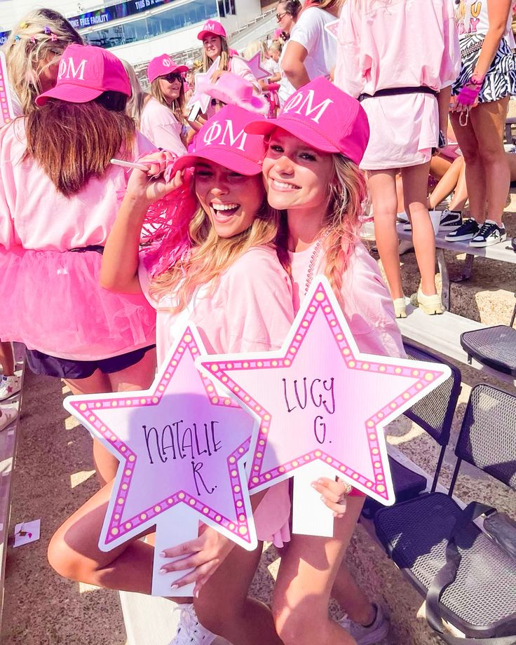 two women in pink hats holding up signs