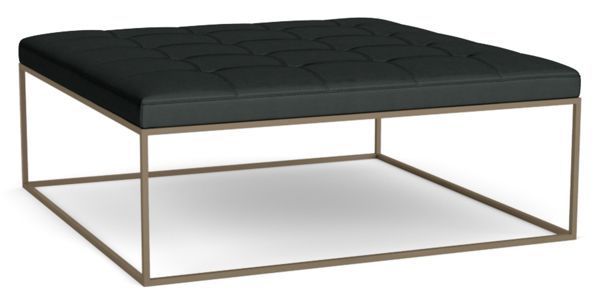 a black ottoman sitting on top of a metal frame with a square foot rest in front of it