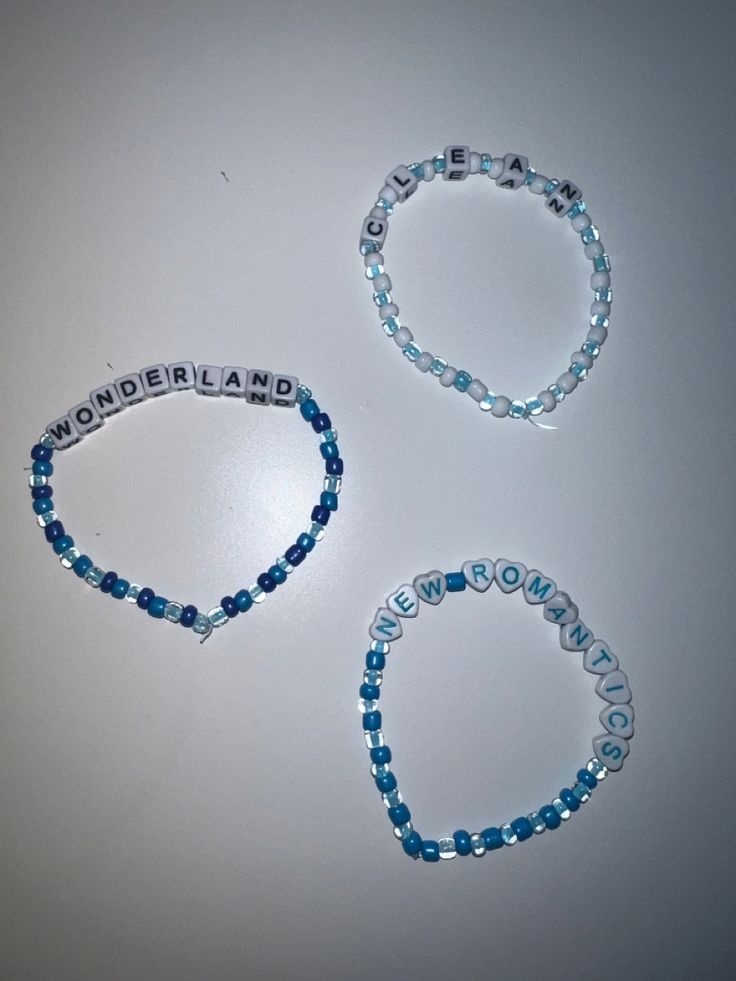 three beaded bracelets with the word wonderland written on one side and two beads in the other