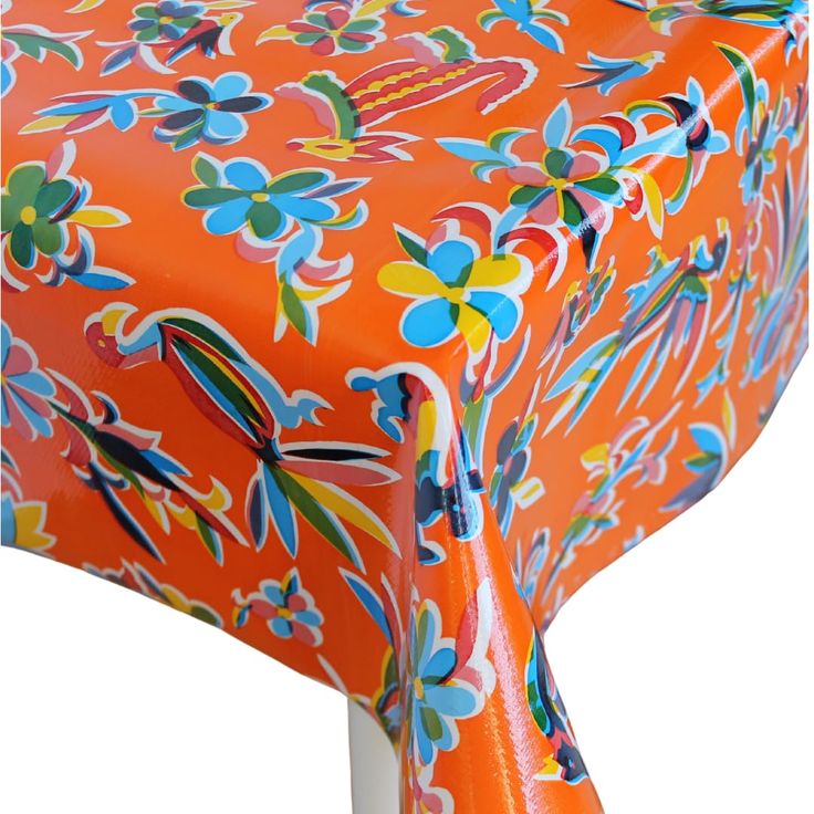 an orange table cloth with colorful flowers on it