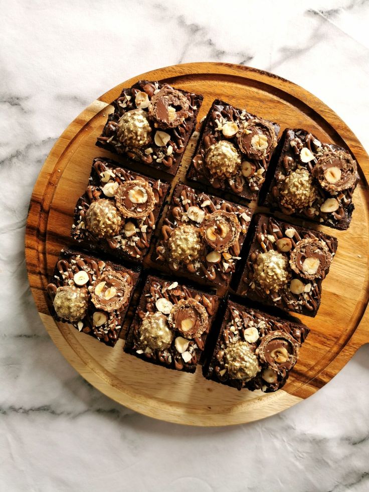 a wooden platter filled with brownies on top of a marble counter