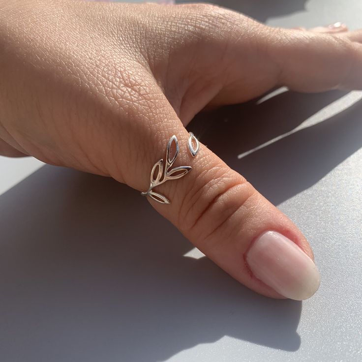 "**Elevate Your Style with Our Silver Leaf Band Thumb Ring 🌿 **Nature-Inspired Beauty This silver leaf band thumb ring draws its inspiration from the beauty of nature. With its delicate leaf design and stackable style, it brings a touch of the outdoors to your everyday look. 💍 **Adjustable for Comfort Crafted for convenience, this cute vine ring ensures a perfect fit on your thumb or any finger. Its adaptability allows you to stack it with other rings or wear it solo, expressing your love for nature effortlessly. 🎁 **Ideal for Gifting Whether it's a birthday celebration or Christmas, this leaf band ring is a thoughtful and charming choice for her. Its craftsmanship and nature-inspired charm will make any occasion extra special. ⭐ **Why Choose Our Silver Leaf Band Thumb Ring - **Nature's Silver Thumb Ring, Delicate Tiny Stackable Rings For Gifts, Dainty Midi Rings For Gifts, Dainty Nickel-free Midi Rings For Anniversary, Dainty Handmade Midi Rings For Anniversary, Delicate Midi Rings With Simple Design As Gift, Delicate Midi Rings With Simple Design For Gift, Adjustable Dainty Toe Rings As Gift, Adjustable Dainty Toe Rings For Gift