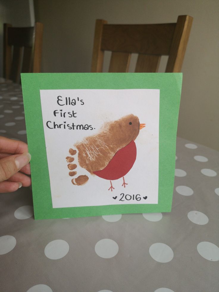 a hand holding up a christmas card with a bird on it