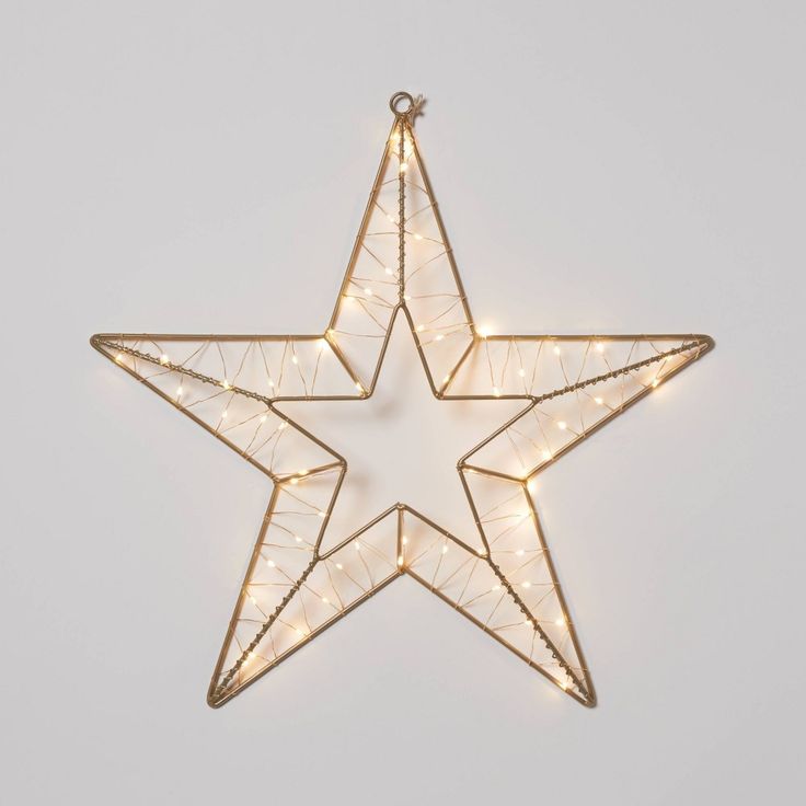 a lighted star ornament hanging on a wall with lights in the shape of a star