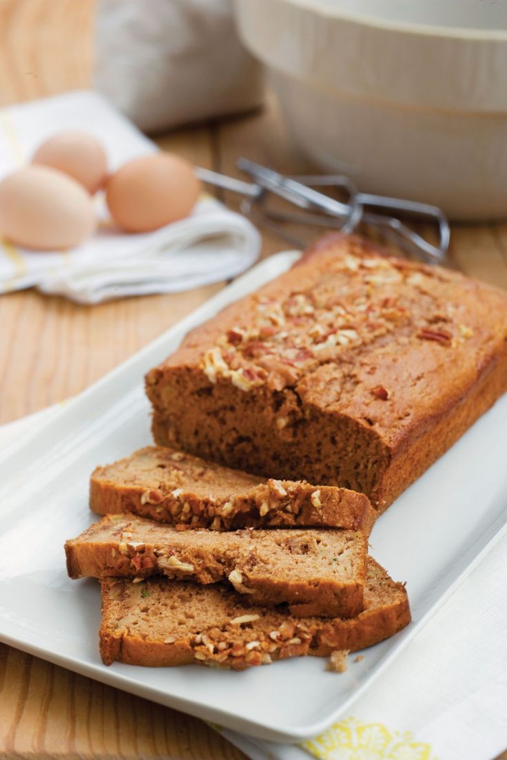 slices of banana bread on a white plate with an egg in the backgroud