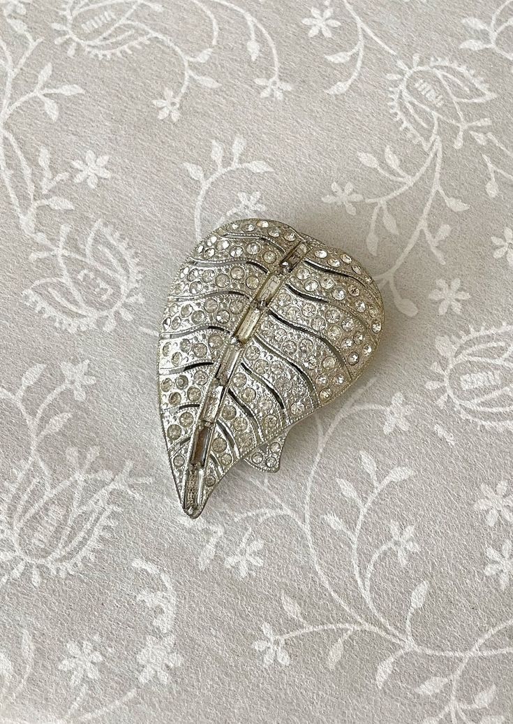 Gorgeous authentic Art Deco era pot metal dress/fur clip with crystal rhinestones!  It is 2 1/16 inches long when closed.  **Missing a few/dark rhinestones.  Priced accordingly.** Circa 1940s. Silver Art Deco Brooches For Wedding, Silver Art Deco Wedding Brooch, Silver Art Deco Wedding Brooches, Glamorous Silver Brooch For Wedding, Wedding Art Deco, Dress Fur, Authentic Art, Metal Dress, Bridal Shrug