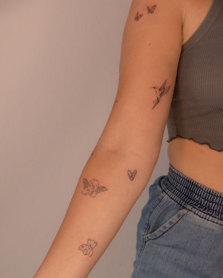 a woman's arm with small tattoos on her left arm and butterfly tattoo on the right arm