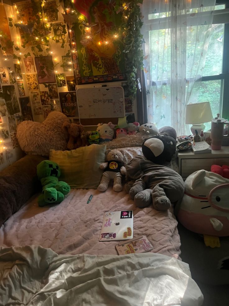 a messy bedroom with stuffed animals on the bed and lights hanging from the wall behind it