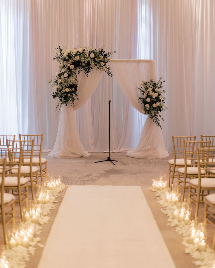 a wedding ceremony setup with white flowers and candles