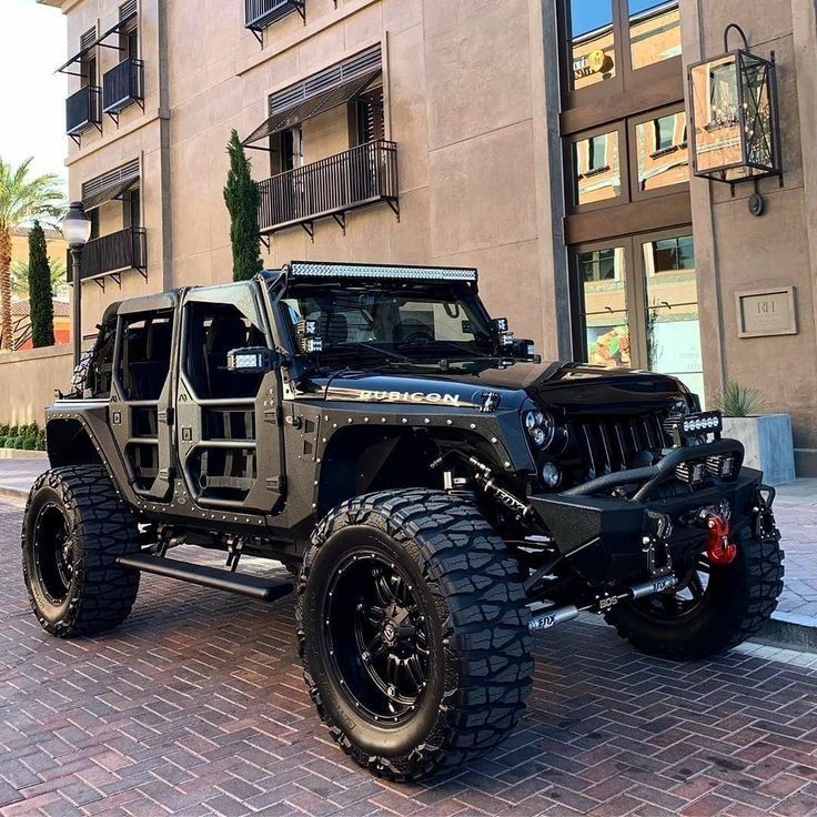 a black jeep parked in front of a tall building