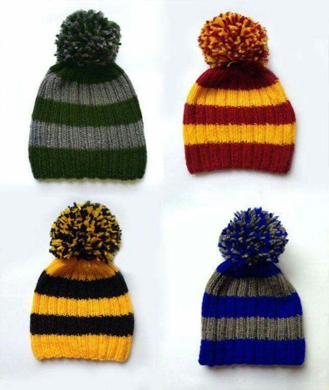 four different colored knitted hats with pom - poms