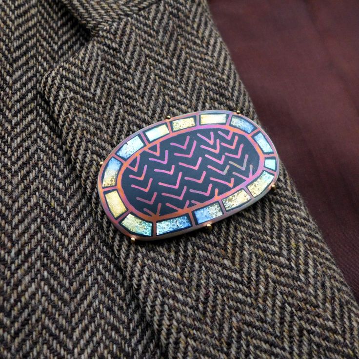 a lapel pin with an abstract design on it