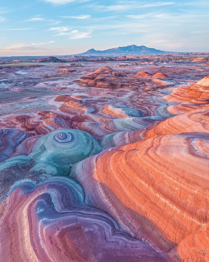 an aerial view of the painted hills and mountains in the distance, with blue sky above