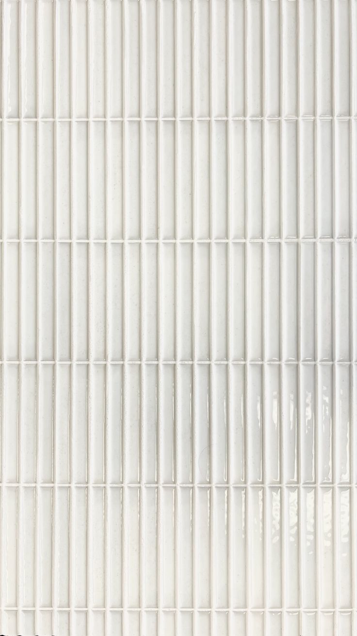 a close up view of a white tile wall with vertical lines in the center and bottom