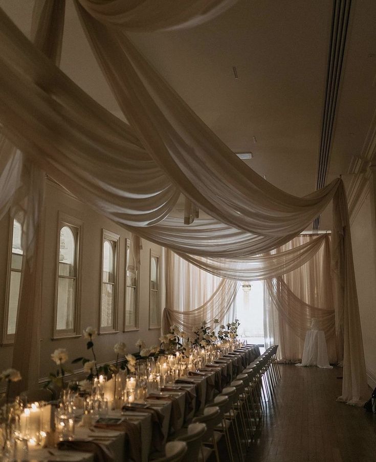 a long table is set with candles and flowers for an elegant wedding reception at the mansion