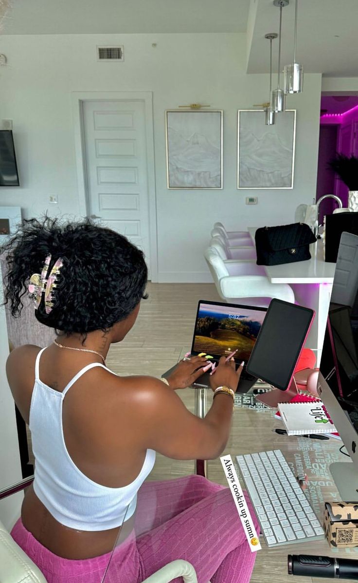 a woman sitting at a desk using a laptop computer