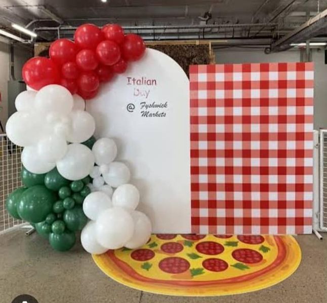 a pizza themed birthday party with balloons and table cloths on the floor in front of it