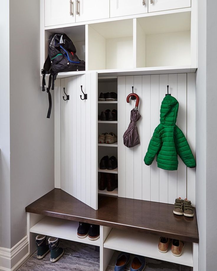 an image of a room with shoes and coat racks on the wall in front of it