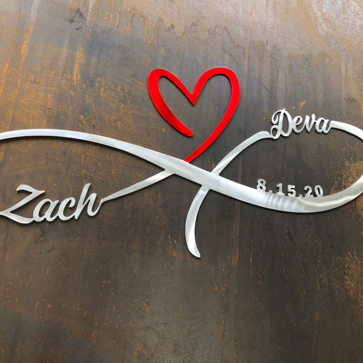 a metal sign with a heart and name on it