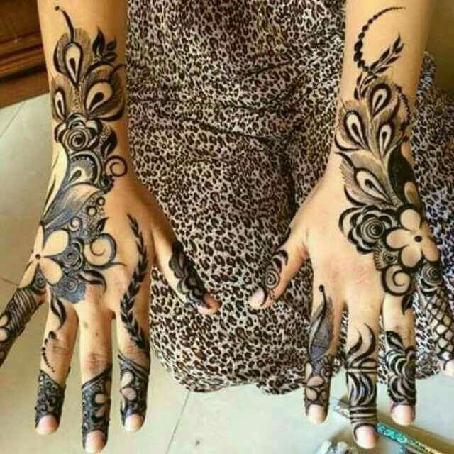 a woman's hands with henna tattoos on them