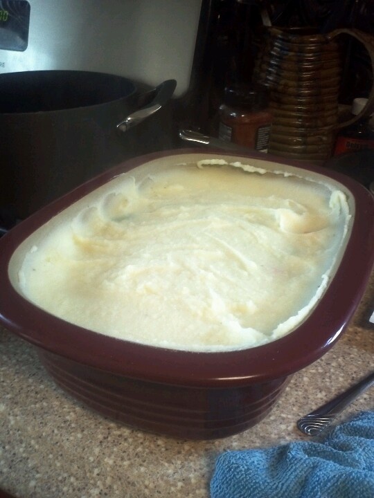 a casserole dish sitting on top of a counter next to a blue towel