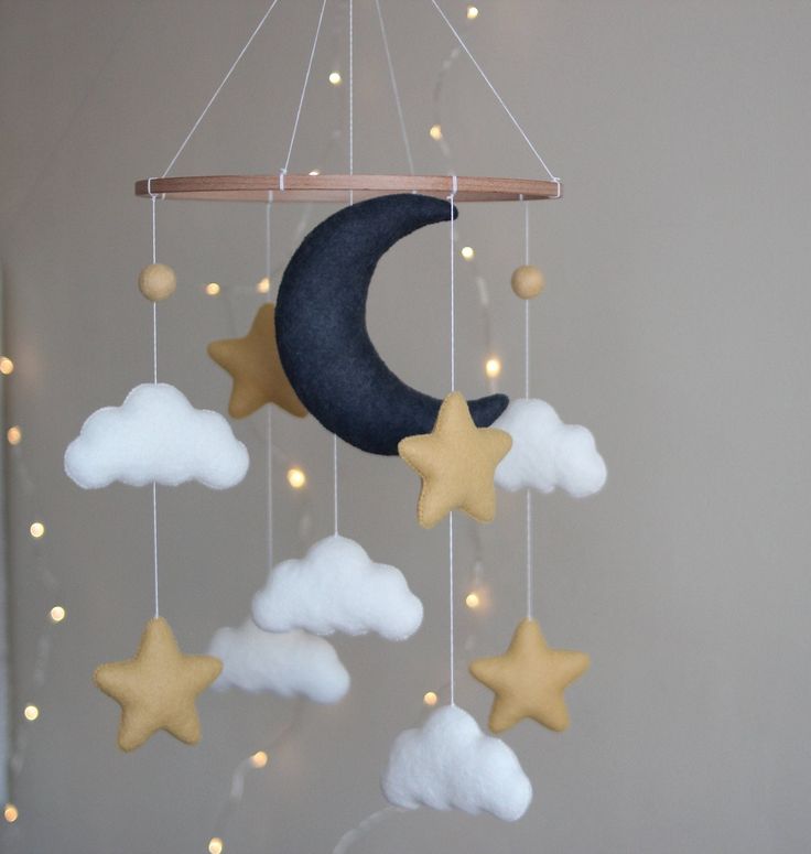 a mobile with stars, moon and clouds hanging from it