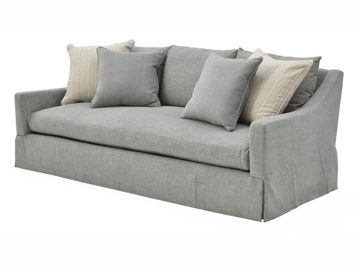 a gray couch with several pillows on it's back and sides, sitting against a white background