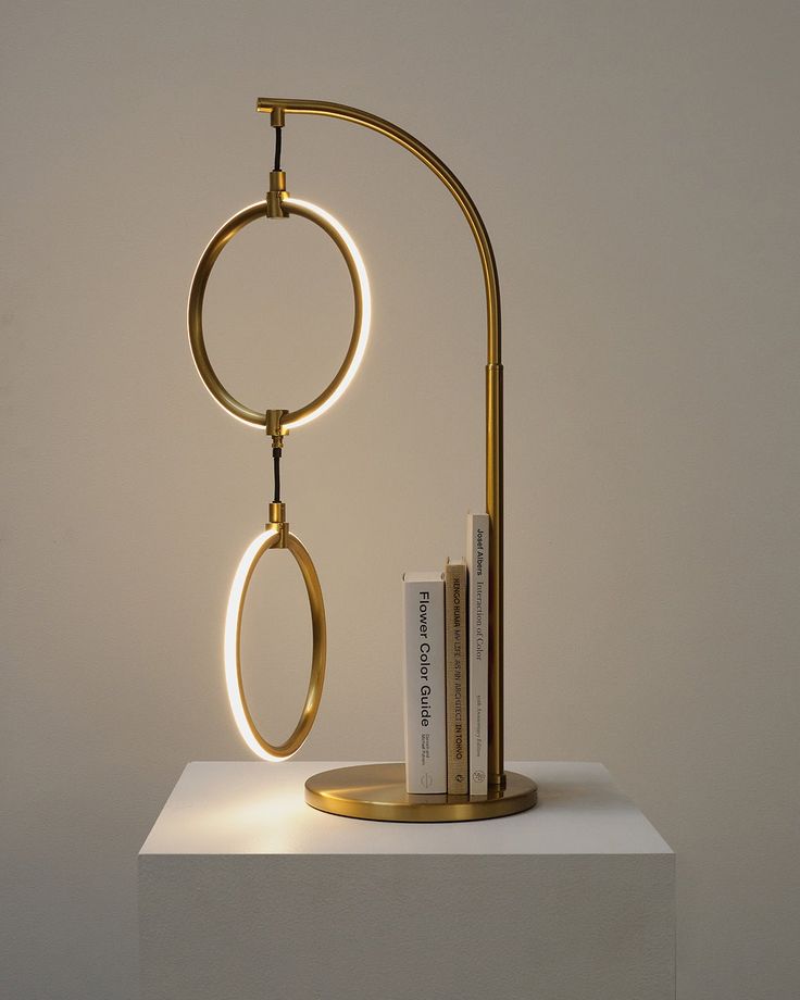 a lamp that is sitting on top of a white table next to a book shelf