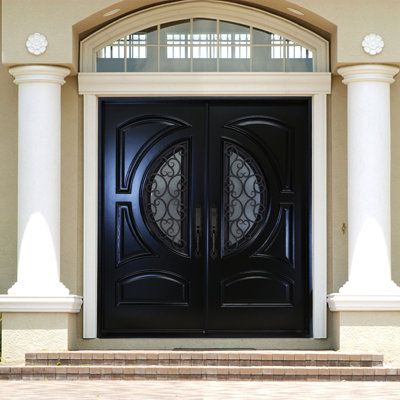 a black double door with two sidelights in front of a beige stucco building and white pillars