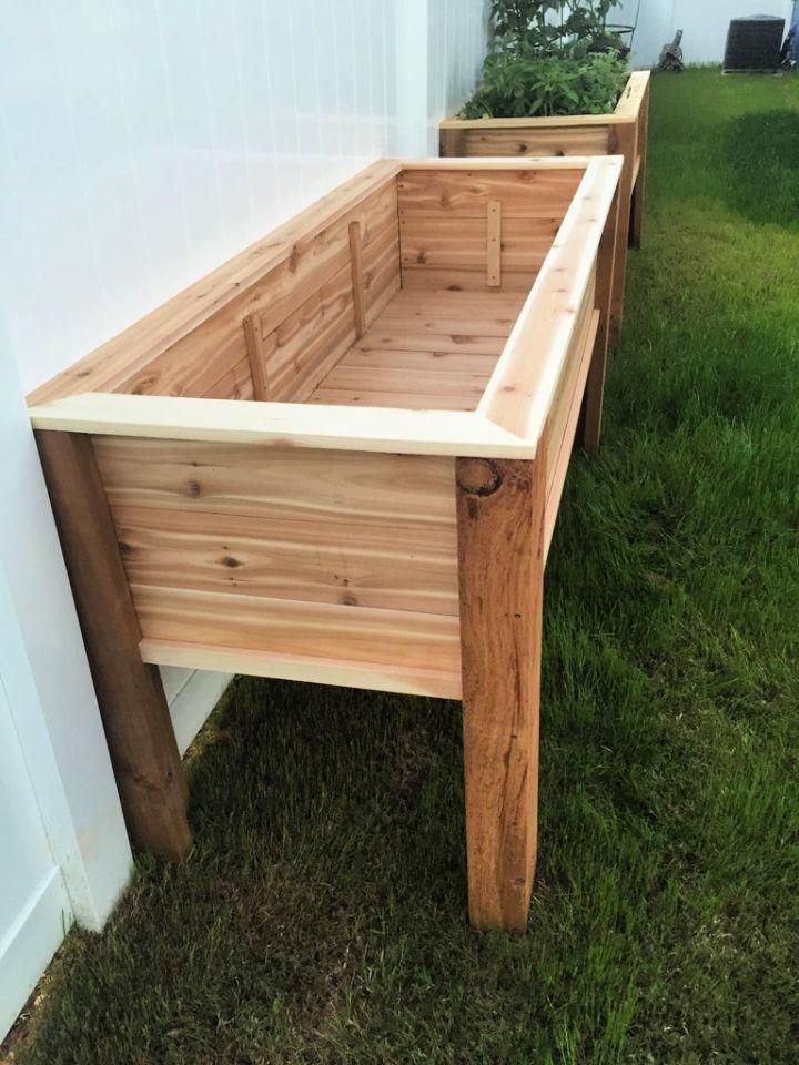 two wooden planters sitting next to each other on the grass